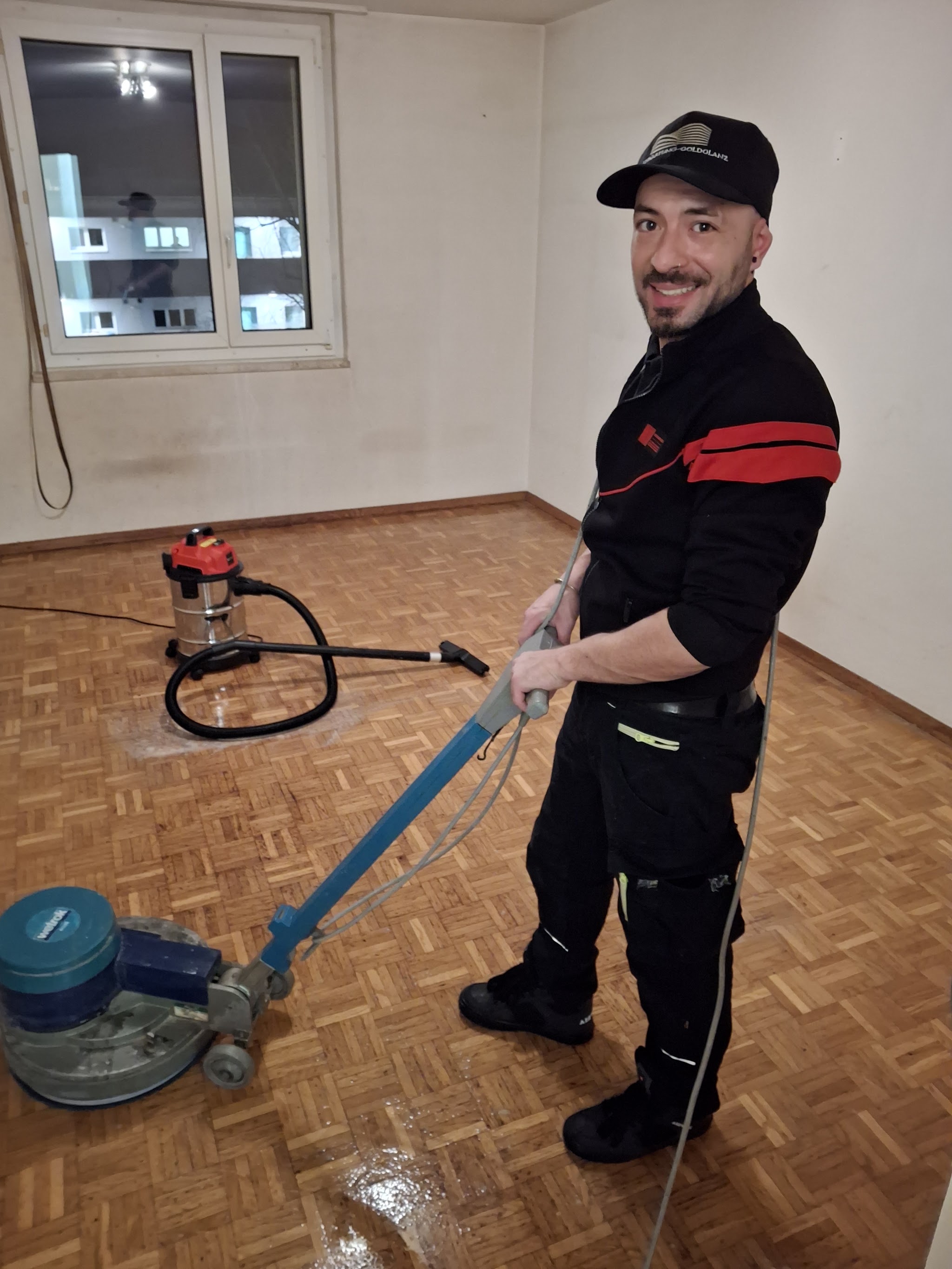 Francisco Dapia reinigt mit einer Einscheibenmaschine einen Parkettboden